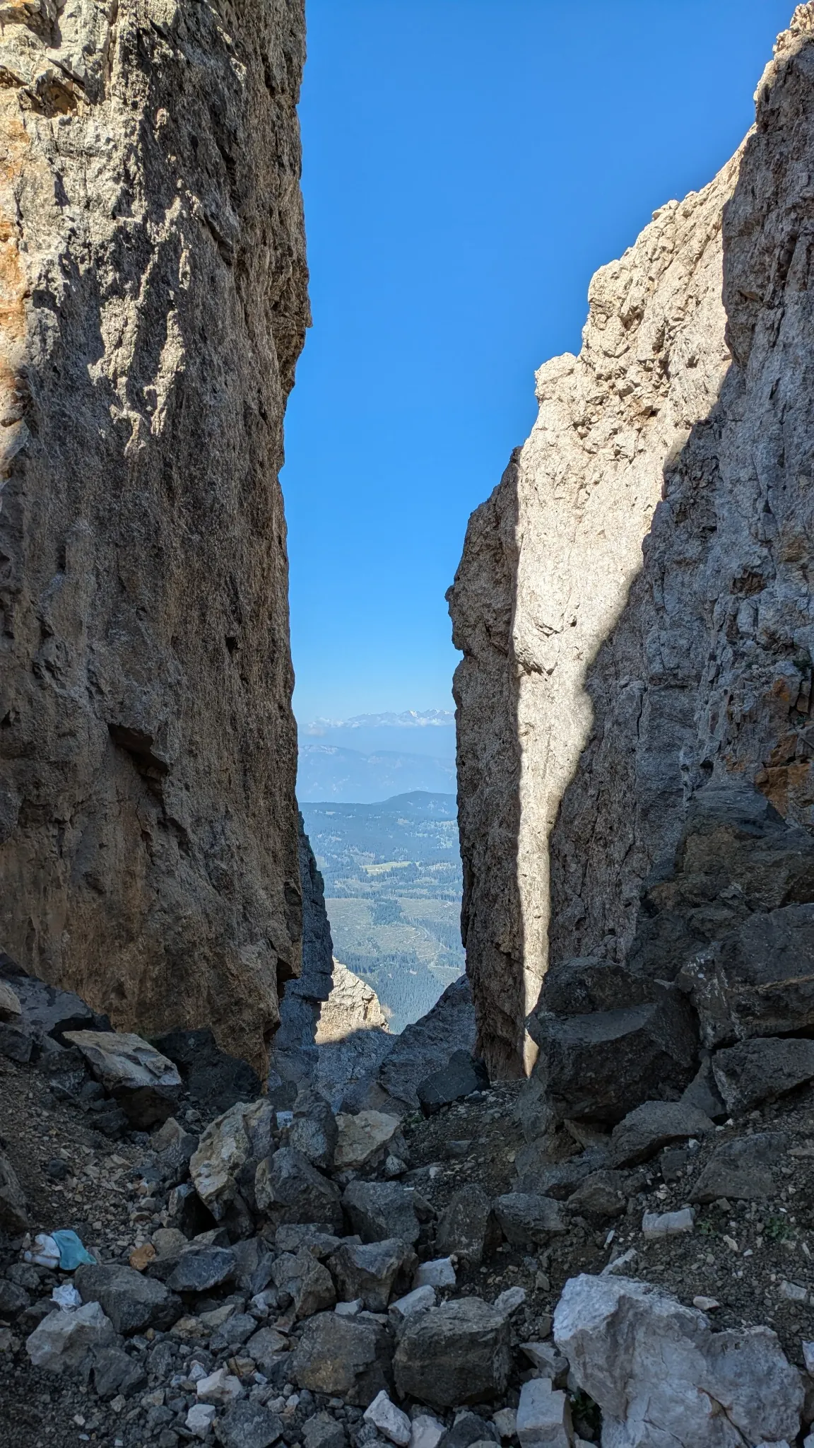 Schmale Felsspalte mit Blick hinaus in die Weite und auf blauen Himmel
